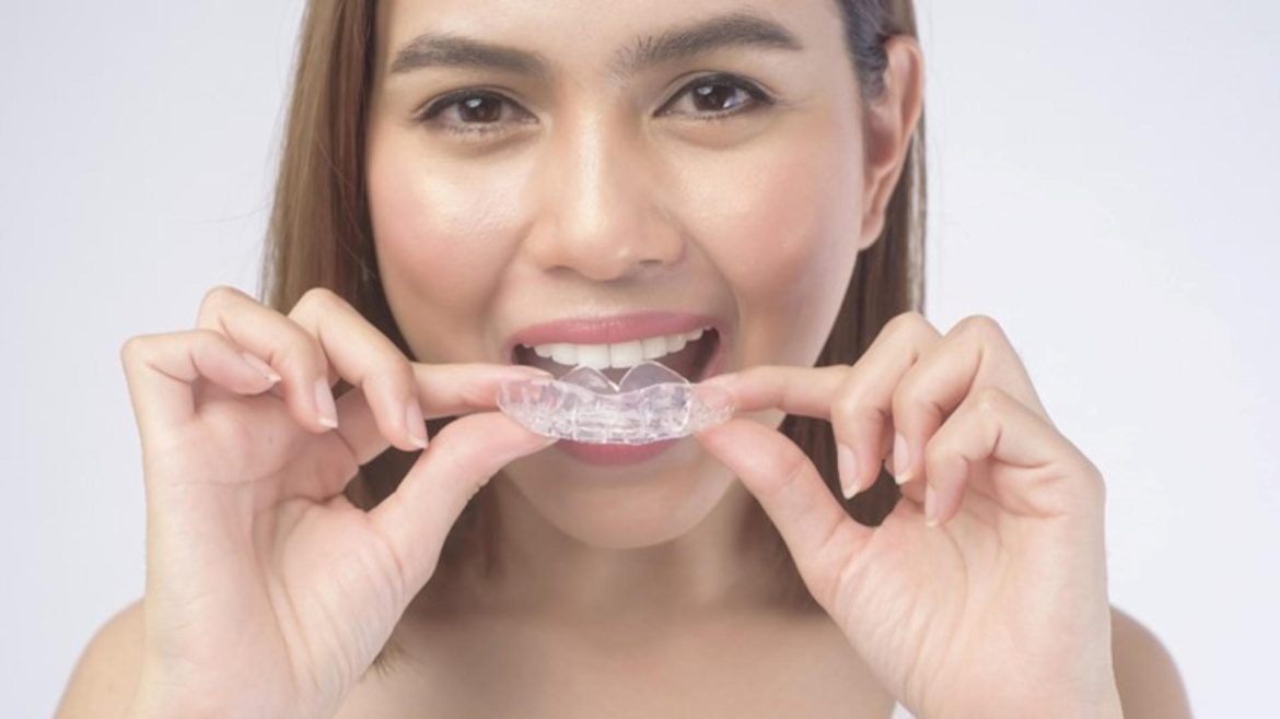 A young lady putting on Invisalign from an Auckland dental clinic
